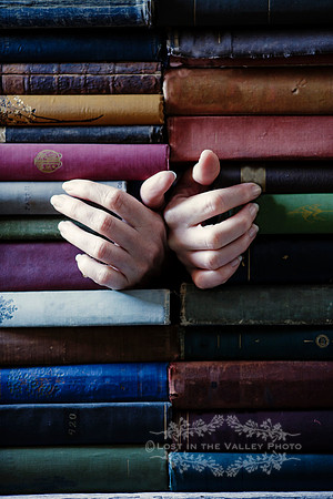 Hands Emerging from a Stack of Old Books