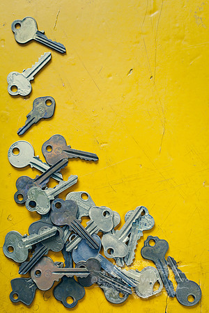 Pile of Worn Keys on a Yellow Background