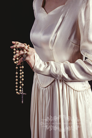 A Young Woman Wearing an Old Fashioned Dress Carrying a Rosary