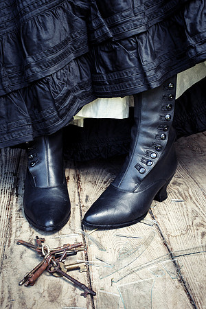 Black Boots Next to Rusting Keys and Broken Glass on the Floor