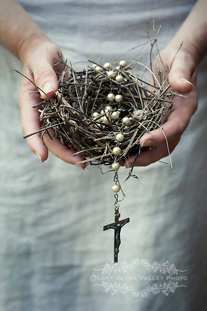 Woman Holding a Bird Nest with Crucifix Necklace