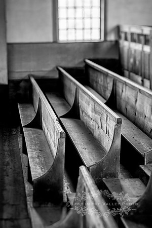black and white photography of wooden benches in an 18th century meetinghouse Vermont